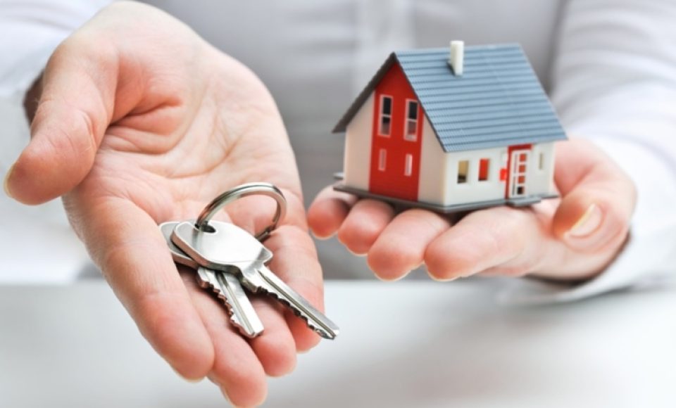Real estate agent with house model and keys