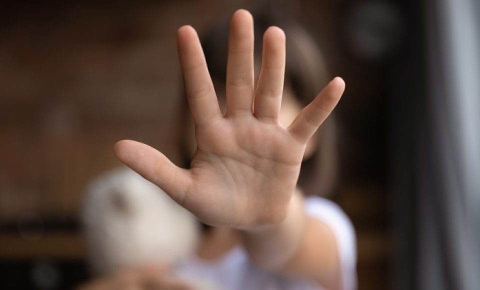 Crop close up of little girl child stretch hand show no gesture protest against domestic violence. Small teen child stand against discrimination or school abuse. Childhood problem, voice concept.