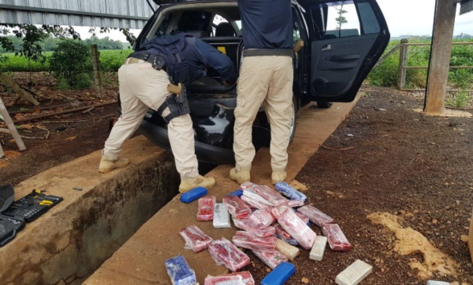 Policiais Rodoviários Federais examinam o carro e encontram os tabletes de maconha (Foto: Divulgação / PRF)